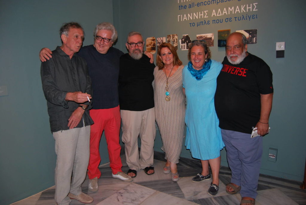 Πλήθος κόσμου, Υδραίων και φιλυδραίων παρευρέθηκαν, το Σάββατο 7 Ιουλίου 2018, στα εγκαίνια της έκθεσης έργων του Γιάννη Αδαμάκη με τον τίτλο «ΤΟ ΜΠΛΕ ΠΟΥ ΣΕ ΤΥΛΙΓΕΙ» που πραγματοποιήθηκαν στην αίθουσα «Διονυσίου και Ίνγκριντ Κουντουριώτη» του ισογείου στο Ιστορικό Αρχείο Μουσείο Ύδρας.